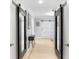 Hallway with custom doors, lots of mirrors and light hardwood flooring at 8203 Kirkwood Dr, Tampa, FL 33634