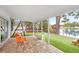 Relaxing outdoor patio with a screened enclosure, playground, and view of the adjacent lake at 8203 Kirkwood Dr, Tampa, FL 33634