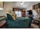 Spacious bedroom featuring a green quilted bedspread, window treatments, and a ceiling fan at 8447 Shallow Creek Ct, New Port Richey, FL 34653