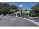 Community clubhouse with palm trees, mature green shrubs, and parking at 8447 Shallow Creek Ct, New Port Richey, FL 34653
