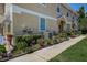 Exterior view of townhome with colorful garden and green lawn next to a sidewalk at 8447 Shallow Creek Ct, New Port Richey, FL 34653