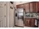 Modern kitchen featuring stainless steel refrigerator and cherry wood cabinets at 8447 Shallow Creek Ct, New Port Richey, FL 34653