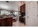 Kitchen with granite countertops and cherry cabinets, next to a desk area and open to the living room at 8447 Shallow Creek Ct, New Port Richey, FL 34653