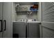 The laundry room contains a full size washer and dryer set with storage shelving at 8447 Shallow Creek Ct, New Port Richey, FL 34653