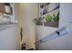 Staircase landing decorated with green plants and an abstract art piece on the wall at 8447 Shallow Creek Ct, New Port Richey, FL 34653