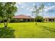 Expansive backyard featuring lush green grass, mature trees, and a charming home with a terracotta-tiled roof at 9313 Lisbon St, Seffner, FL 33584