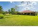 Expansive backyard featuring lush green grass and a charming home with a terracotta-tiled roof at 9313 Lisbon St, Seffner, FL 33584