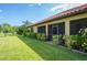 A screened in patio, manicured shrubbery, and terracotta-tiled roof along the back of the home at 9313 Lisbon St, Seffner, FL 33584