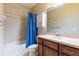 Bathroom featuring a vanity with sink, toilet, and a bathtub with a shower and blue curtain at 9313 Lisbon St, Seffner, FL 33584