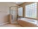 Bathroom featuring a bathtub and separate glass shower with stylish tile work and a window at 9313 Lisbon St, Seffner, FL 33584
