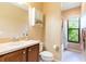 Well-lit bathroom featuring a vanity with a sink and mirror, toilet, and shower-tub combination at 9313 Lisbon St, Seffner, FL 33584