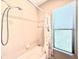 Bathroom featuring a shower and tub combo, tile surround, shower head and a window at 9313 Lisbon St, Seffner, FL 33584