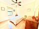 Sunny bedroom featuring hardwood floors, ceiling fan and a large window at 9313 Lisbon St, Seffner, FL 33584