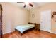 Cozy bedroom with hardwood floors, wood frame bed, ceiling fan, and natural light at 9313 Lisbon St, Seffner, FL 33584