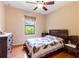 Bedroom featuring hardwood floors, a ceiling fan and a window providing natural light at 9313 Lisbon St, Seffner, FL 33584