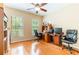 Bright bedroom featuring hardwood floors, two large windows, desk, and a ceiling fan at 9313 Lisbon St, Seffner, FL 33584