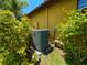 View of home's air conditioning unit surrounded by lush foliage at 9313 Lisbon St, Seffner, FL 33584