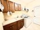 Well-equipped laundry room with cabinets, sink, and modern washer and dryer at 9313 Lisbon St, Seffner, FL 33584