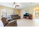 Comfortable living room with reclining sofas, a ceiling fan, tile floors, and natural light at 9313 Lisbon St, Seffner, FL 33584