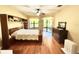 Spacious main bedroom with built in shelf, wood flooring, ceiling fan and a view to the outside patio at 9313 Lisbon St, Seffner, FL 33584
