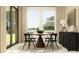 Bright dining area with round wooden table and a view to the backyard at 9376 Gladsome Dr, Land O Lakes, FL 34637