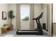 Bright exercise room with large window and modern treadmill at 9376 Gladsome Dr, Land O Lakes, FL 34637
