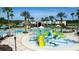 Community pool area includes a large swimming pool, splash zone for , and palm trees creating a resort-like atmosphere at 9376 Gladsome Dr, Land O Lakes, FL 34637