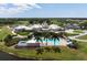 Aerial shot of community clubhouse with pool, parking and surrounding golf course at 984 Chickadee Dr, Venice, FL 34285