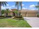 Stunning home exterior showcasing lush landscaping, a well-manicured lawn, and a brick-paved driveway at 984 Chickadee Dr, Venice, FL 34285