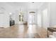 Bright living room showcasing a chandelier, tile flooring, and elegant doorway with decorative glass inserts at 984 Chickadee Dr, Venice, FL 34285