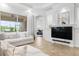 Living room area displaying plush seating, a large TV, and access to a screened patio at 984 Chickadee Dr, Venice, FL 34285