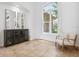 Bright living room featuring tile floors, a dark cabinet, and large arched window at 984 Chickadee Dr, Venice, FL 34285
