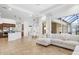 Bright, open-concept living room with tile floors and a view of the enclosed lanai at 984 Chickadee Dr, Venice, FL 34285