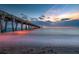 Long exposure of a wooden pier extending over the ocean into a vibrant sunset sky at 984 Chickadee Dr, Venice, FL 34285