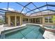 Stunning screened-in pool with spa, tile surround, and covered seating area at 984 Chickadee Dr, Venice, FL 34285