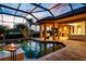 Outdoor seating area with a fire pit by the pool, perfect for relaxing and entertaining guests at 984 Chickadee Dr, Venice, FL 34285