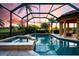 A luxurious screened-in pool and spa area offer serene outdoor living with a picturesque sunset view at 984 Chickadee Dr, Venice, FL 34285
