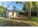 The backyard features a covered patio perfect for outdoor entertaining, surrounded by mature trees and lush greenery at 9834 Miramar St, New Port Richey, FL 34654