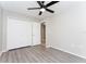 Comfortable bedroom featuring laminate flooring, a modern ceiling fan, and ample closet space for storage solutions at 9834 Miramar St, New Port Richey, FL 34654