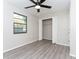This bright bedroom features a window for natural light, laminate floors, a ceiling fan and double door closet at 9834 Miramar St, New Port Richey, FL 34654
