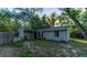 Charming home exterior showcasing a well-maintained lawn, mature trees and an attached garage at 9834 Miramar St, New Port Richey, FL 34654