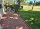 Paver patio with view of lawn and golf course beyond hedge at 9127 Woodridge Run Dr, Tampa, FL 33647