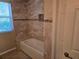 Tiled bathroom featuring a bathtub and shower at 9127 Woodridge Run Dr, Tampa, FL 33647