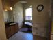 Elegant bathroom features a clawfoot tub, natural stone accents, and wood look flooring at 9127 Woodridge Run Dr, Tampa, FL 33647