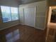 Bedroom with hardwood floors, closet, and window for natural light at 9127 Woodridge Run Dr, Tampa, FL 33647