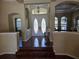 Bright foyer featuring decorative glass double doors, chandelier, and hardwood flooring at 9127 Woodridge Run Dr, Tampa, FL 33647