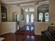 Bright foyer featuring decorative glass double doors, chandelier, and hardwood flooring at 9127 Woodridge Run Dr, Tampa, FL 33647