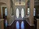 Bright foyer featuring decorative glass double doors, chandelier, and hardwood flooring at 9127 Woodridge Run Dr, Tampa, FL 33647