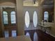 Bright foyer featuring decorative glass double doors, chandelier, and hardwood flooring at 9127 Woodridge Run Dr, Tampa, FL 33647