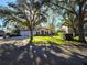 Attractive home with mature trees, manicured landscaping, barrel tile roof, and a circular driveway at 9127 Woodridge Run Dr, Tampa, FL 33647
